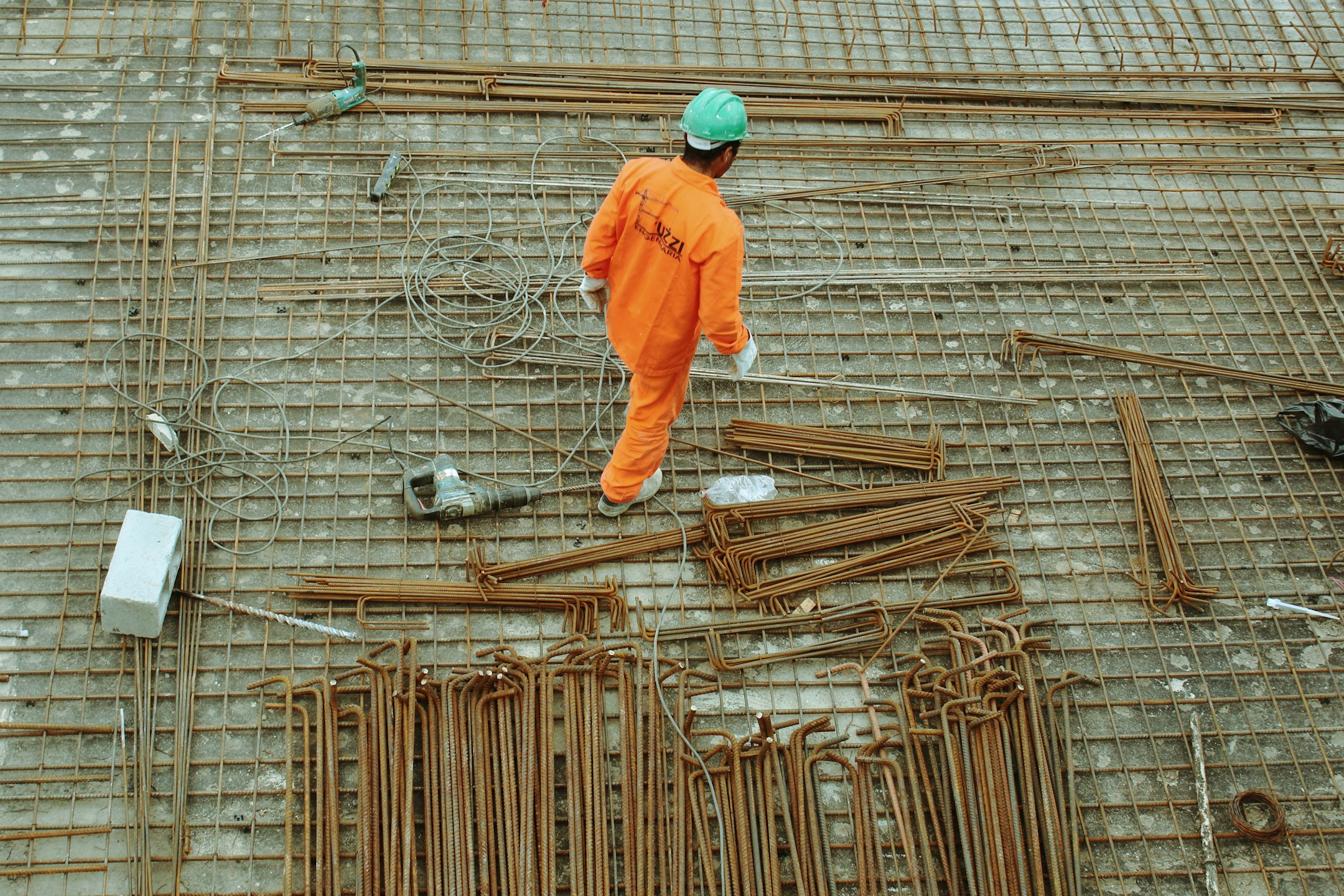 Construction worker installing reinforcement bars on site